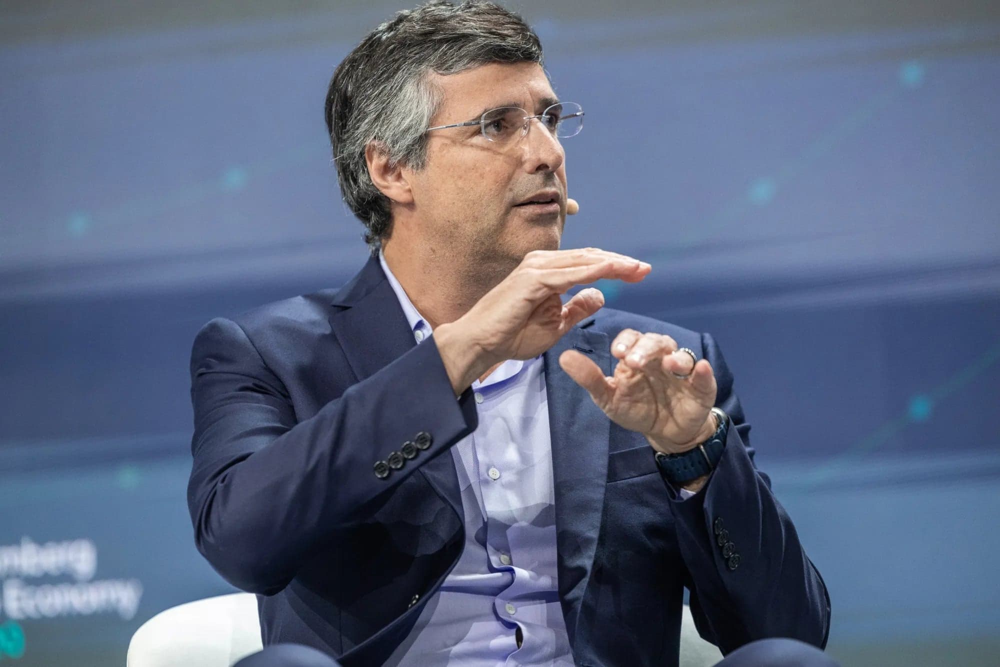 André Esteves gestures with both hands while speaking on stage at a Bloomberg event
